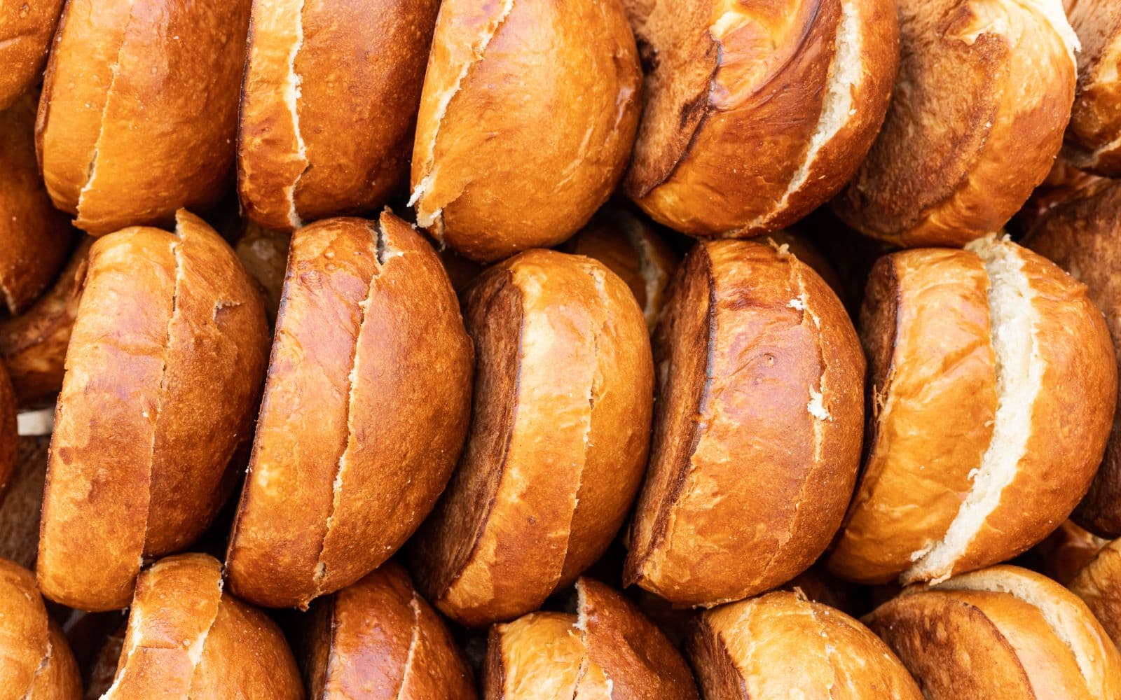 Freshly baked potato buns cooling on racks at Fournos Lambros